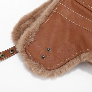 Detailed view of brown leather aviator hat with faux fur lining and white contrast stitching