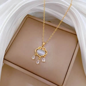 Elegant gold necklace featuring a lucky lock pendant with white cat-eye stone and zircons
