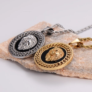 Gold and silver lion head pendant necklaces with twisted chains on stone background