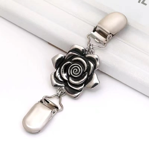 Détail d'un clip à pull vintage argenté avec décoration de rose sculptée
