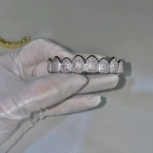 Macro shot of silver hip hop grillz with inlaid cubic zirconia and eight-tooth design