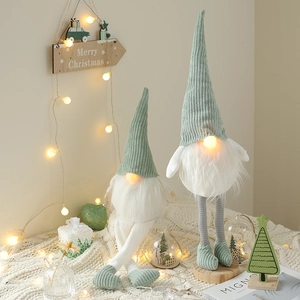 Set of two glowing Christmas gnomes in sage green and cream with LED light decoration