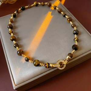 Collana di pietre occhio di tigre con chiusura placcata oro su vassoio di lusso