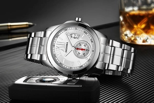 Detailansicht einer Herrenuhr mit römischen Ziffern und Kalender auf dunklem Tisch