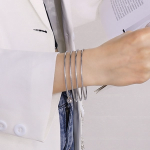 Minimalist multi-layer silver stainless steel bangle shown on a model's wrist
