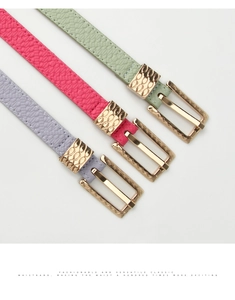 Detailed view of women's slim leather belts in green, pink and purple with gold buckles