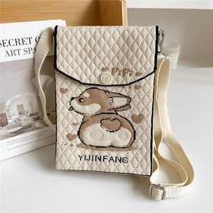 Detail of cream knit crossbody phone bag with cute corgi pattern and logo strap
