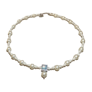 Collier de perles plaqué or 18 carats avec pendentif opale bleue vintage sur fond blanc