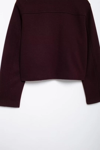 Dettaglio posteriore di una giacca di lana bordeaux con cuciture sartoriali di pregio