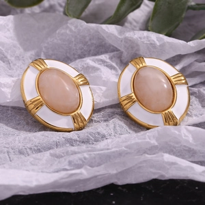 Macro detail of oval 18K gold plated earring with white enamel and starburst texture