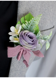 Detail of dusty rose artificial rose boutonniere on grey wool suit with satin ribbon