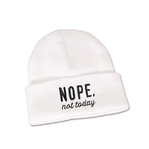 Detail einer weißen Rippstrickmütze mit NOPE not today Stickerei auf dem Umschlag