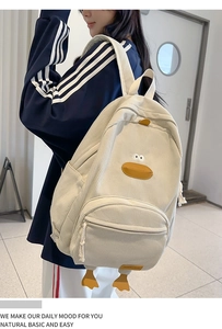 Detail view of a cute cream white corduroy backpack with cartoon duck features and 3D feet