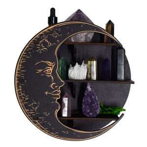 Detail of moon-shaped wooden shelf with gold sun and star engravings for crystals