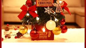 Detail of mini Christmas tree with LED lights, red ribbons, and festive wooden ornaments