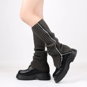 Detailed view of dark grey knitted leg warmers with silver zipper and ribbed texture