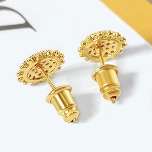Macro shot of 18k gold plated floral stud earrings with radiant cubic zirconia center