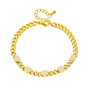 Golden Cuban chain bracelet with white rhinestone heart charms on a white background