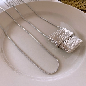 Detailed view of silver woven rectangular pendant on a sleek snake chain necklace