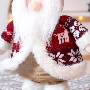 Close-up of a Christmas gnome figurine with red knitted elk pattern and white faux fur