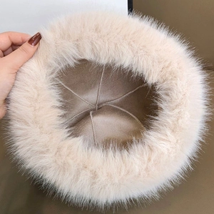 Detail of plush off-white faux fur hat showing thick texture and warm brown fabric lining