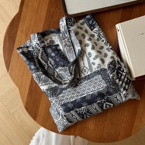Détails macro du sac en lin à motif paisley bohème sur une table en bois rustique