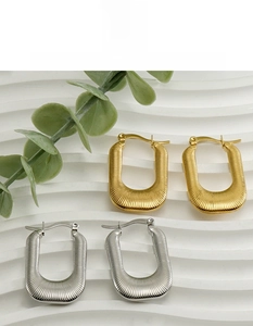 Détail macro de boucles d'oreilles en U en acier inoxydable doré et argenté avec rainures