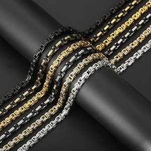 Detail of Byzantine style chains in black, gold, and silver finishes on a textured base