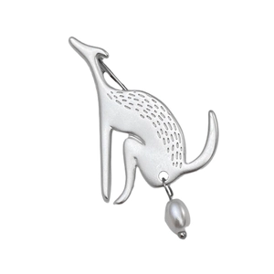 Macro detail of a silver kangaroo brooch with fine engravings and a dangling pearl