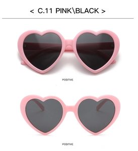 Detailed view of pink heart-shaped sunglasses frames with dark gray polarized lenses
