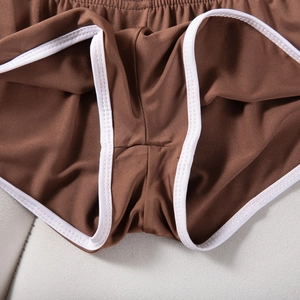 Detailansicht brauner Sport-Shorts mit weißem Kontrastsaum und elastischem Material