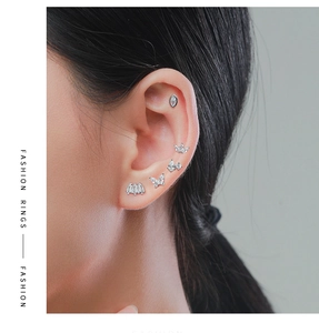 Detailed view of S925 sterling silver ear studs with butterfly and crown zircon designs
