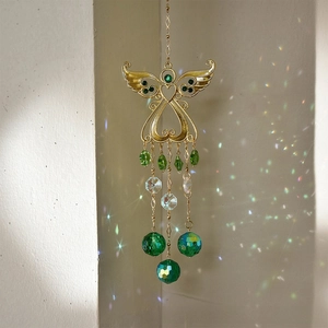 Detail of golden angel suncatcher with green crystal beads reflecting rainbow light on wall