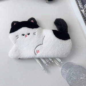Macro shot of cute plush cat pencil case showing pink ear details and soft cow-pattern fur