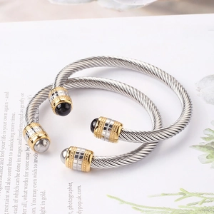 Close-up of titanium steel twisted cable bracelets with black onyx beads and square pattern