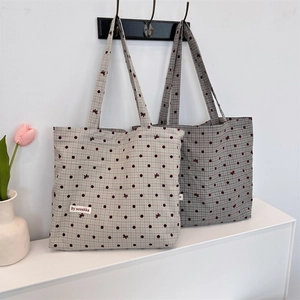 Vue détaillée de sacs cabas en toile avec pois rouges et motifs à carreaux sur comptoir