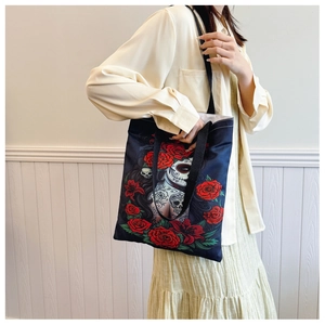 Close-up of skeleton girl with red roses art print on a black canvas tote bag