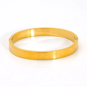 Macro detail of the 18K gold-plated stainless steel bangle with polished finish