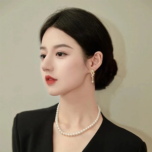 Elegant natural freshwater pearl drop earrings and necklace set worn by a female model
