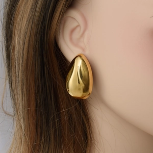 Polished golden 18k teardrop earrings on model for a minimalist fashion look
