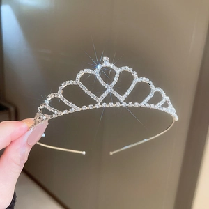 Dettaglio di un cerchietto a corona argento con strass scintillanti e perle