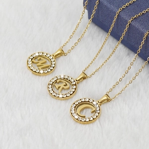 Vue détaillée de trois pendentifs lettres en or 18K avec accents de diamants brillants