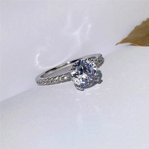 Elegant silver solitaire ring with round brilliant cut zircon and pavé diamond band
