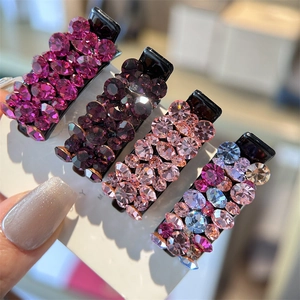 Gros plan de petites barrettes à cheveux ornées de strass brillants violets et roses