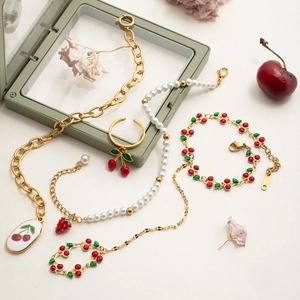 Gold chain necklace and bracelet set with red cherry charms and pearl strawberry details