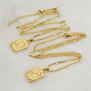 Detail of 18K gold-plated stainless steel Figaro chain with square A and K letter pendants