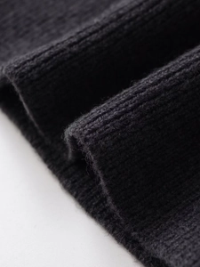 Gros plan sur un tricot côtelé noir montrant la texture douce et les détails des fibres