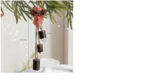 Close-up of vintage metal Christmas bells with checkered bow and holly berry on pine branch