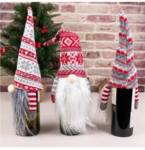 Three festive Christmas gnome wine bottle covers with knitted hats and faux fur beards