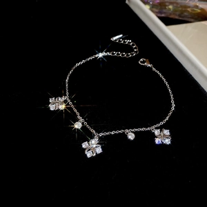 Detailed macro view of silver zircon flower charms on a delicate minimalist chain